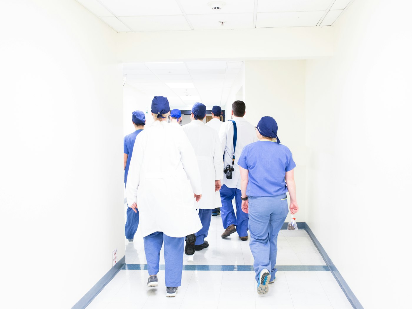 Clinical staff walking a light-filled hospital corridor